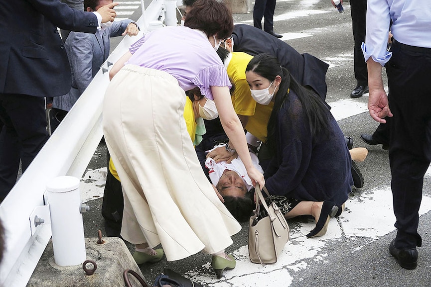 Former Japanese prime minister Shinzo Abe lies on the ground after apparent shooting during an election campaign for the Upper House election, in Nara, western Japan July 8, 2022. Photo: Kyodo via Reuters