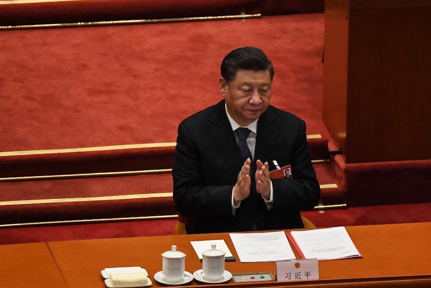 China's President Xi Jinping applauds during the closing session of the National Peopleís Congress (NPC) at the Great Hall of the People in Beijing on March 11, 2022. (Photo by Leo RAMIREZ / AFP)