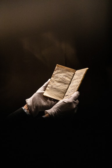 Mark Davidson, the curator of the Dylan Archive, holds an original notebook containing handwritten Bob Dylan lyrics, at the Bob Dylan Center in Tulsa, Okla., April 30, 2022. A new space to display Dylan’s vast archive, celebrates one of the world’s most elusive creators, and gives visitors a close-up look at notebooks and fan mail. (Joseph Rushmore/The New York Times)