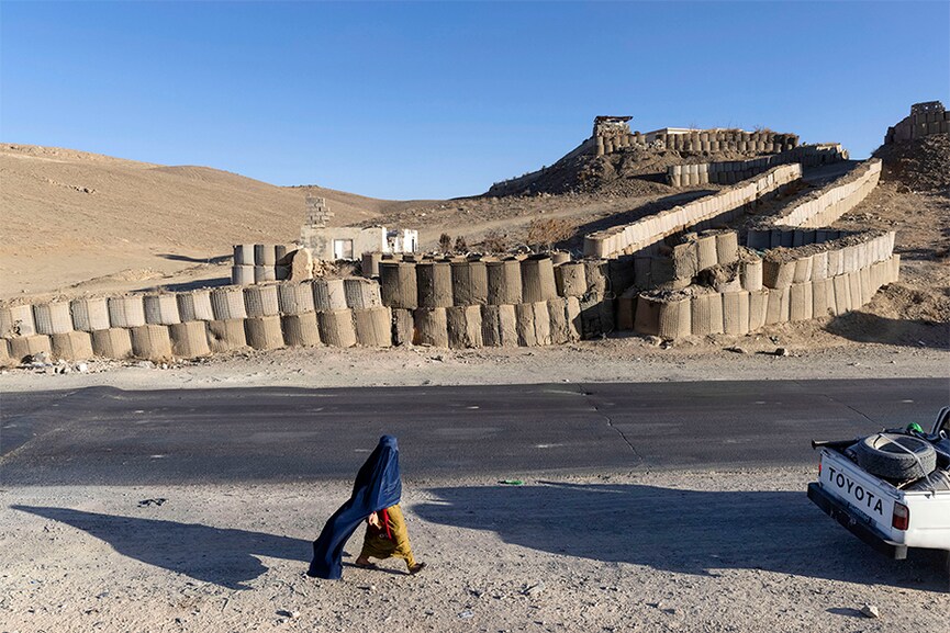 FILE — A woman walks along the side of the Kabul–Kandahar Highway north of Ghazni, Afghanistan, in Dec. 8, 2021. The Afghan government stated that a “hijab” should cover not only a woman’s hair and face, but her entire body from head to toe.  Image: David Guttenfelder/The New York Times