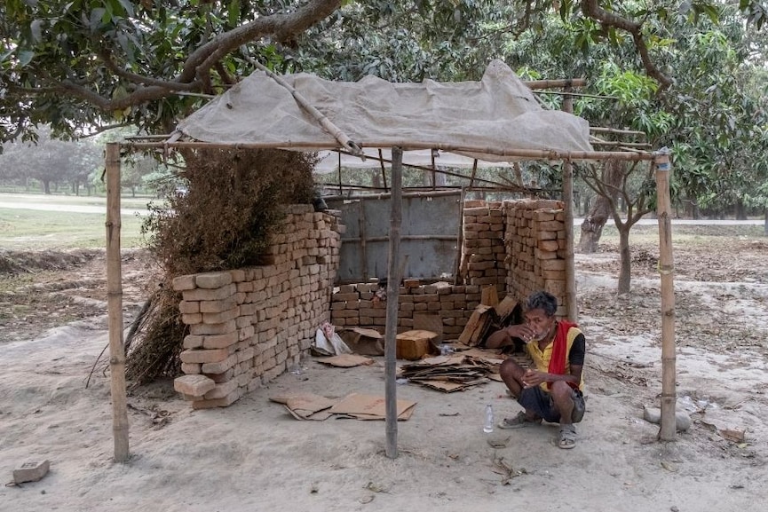 A man drinks Nepali-made alcohol in a mango orchard along the border with India, near Maruwai, Nepal, April 15, 2022. Since the Indian state of Bihar banned alcohol in 2016, a small industry of bars and restaurants has sprung up just across the border in Nepal, catering to Indians of all classes seeking to quench their thirst. Image: Saumya Khandelwal/The New York Times