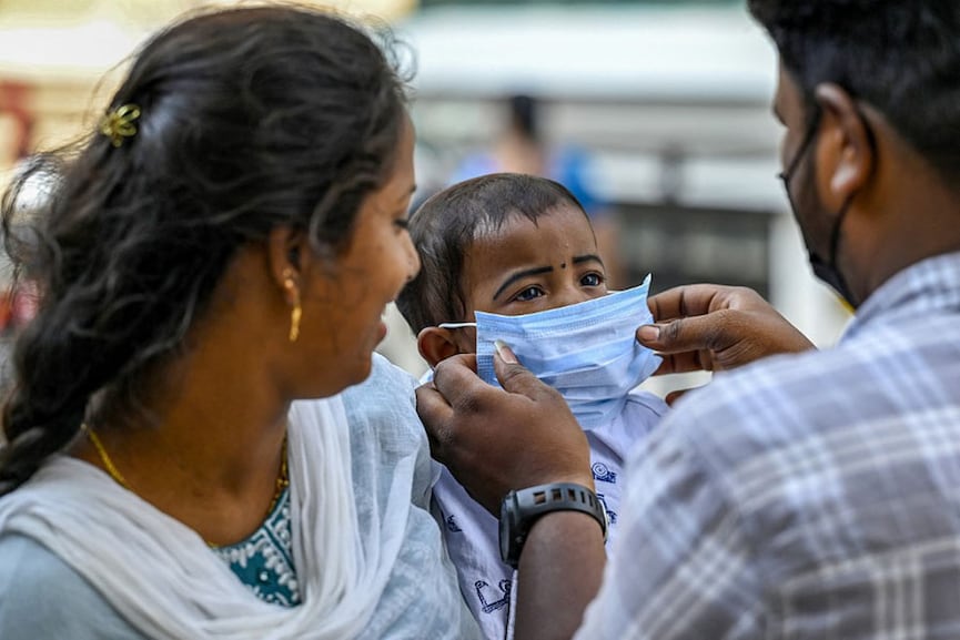 A parent helps a child wear a face mask at a government hospital in Chennai, amidst a rise in Covid-19 coronavirus cases, on April 1, 2023.
Image: R.Satish Babu / AFP