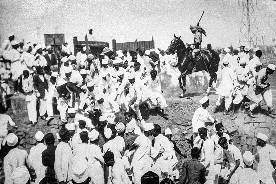 A soldier under British command beats satyagrahis with a lathi at Wadala salt pans while they spirit away some salt without paying tax in defiance of laws. Image: Bettmann