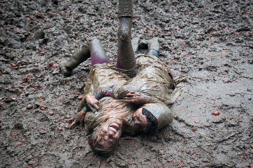 Two festival revellers roll in the mud after taking part in a tomato fight at the Glastonbury Festival 2016. 