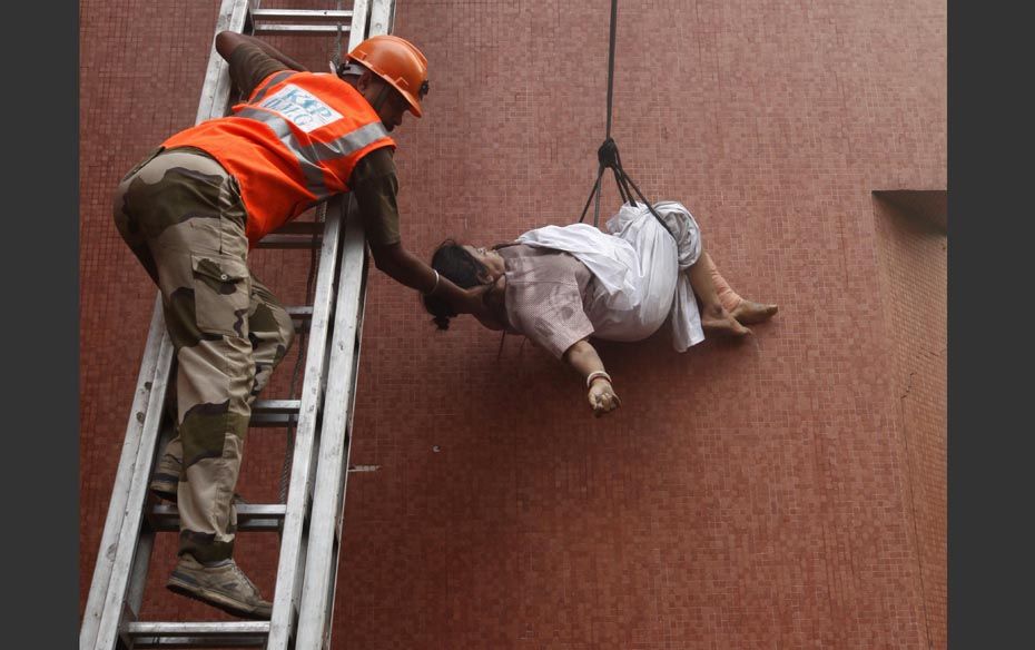 A fire-fighter evacuates a patient from AMRI Hospitals in Kolkata on December 9. The fire that swept