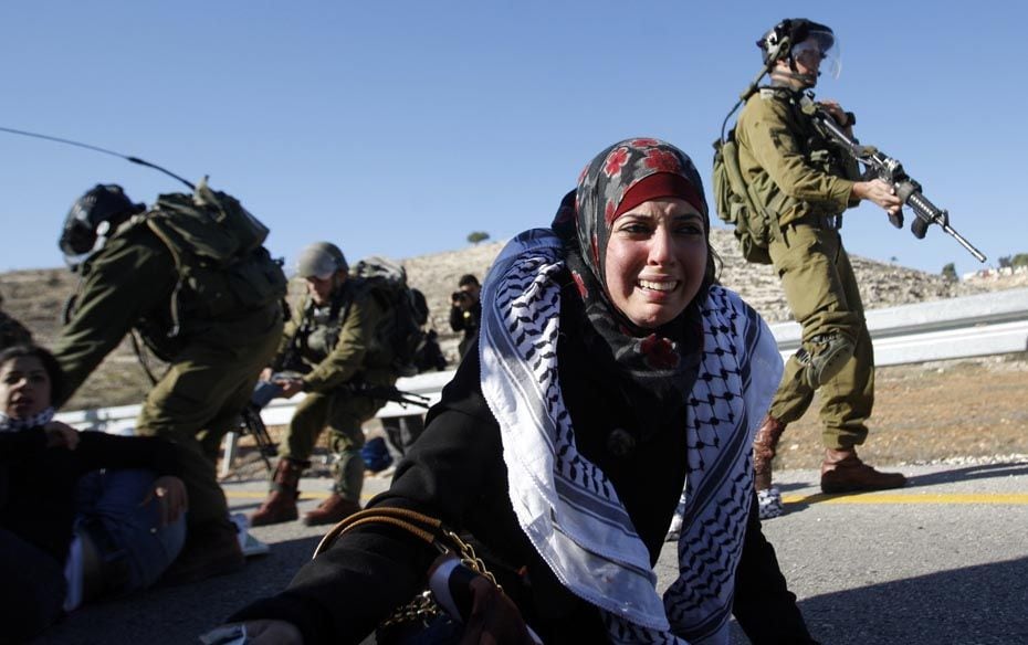 A Palestinian girl weeps as Israeli soldiers detain activists in the West Bank on December 11 during