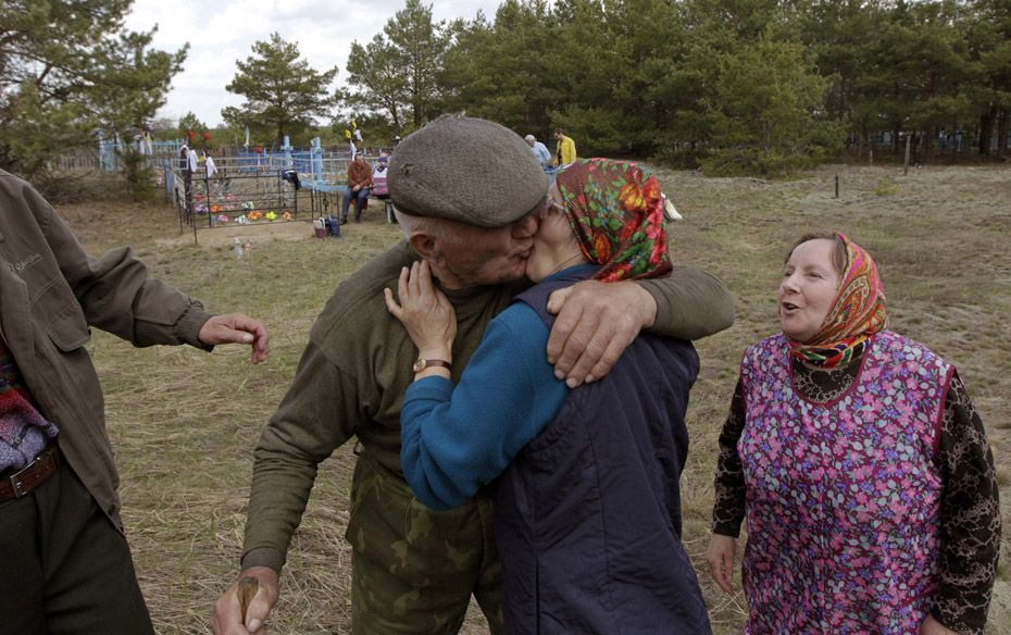 Villager Ivan Shamianok (L), 87, meets with former neighbours on the eve  of "Radunitsa", 