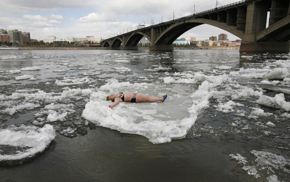 A member of the Cryophil winter swimmers club lies on floating ice from the spring melting on the Ye