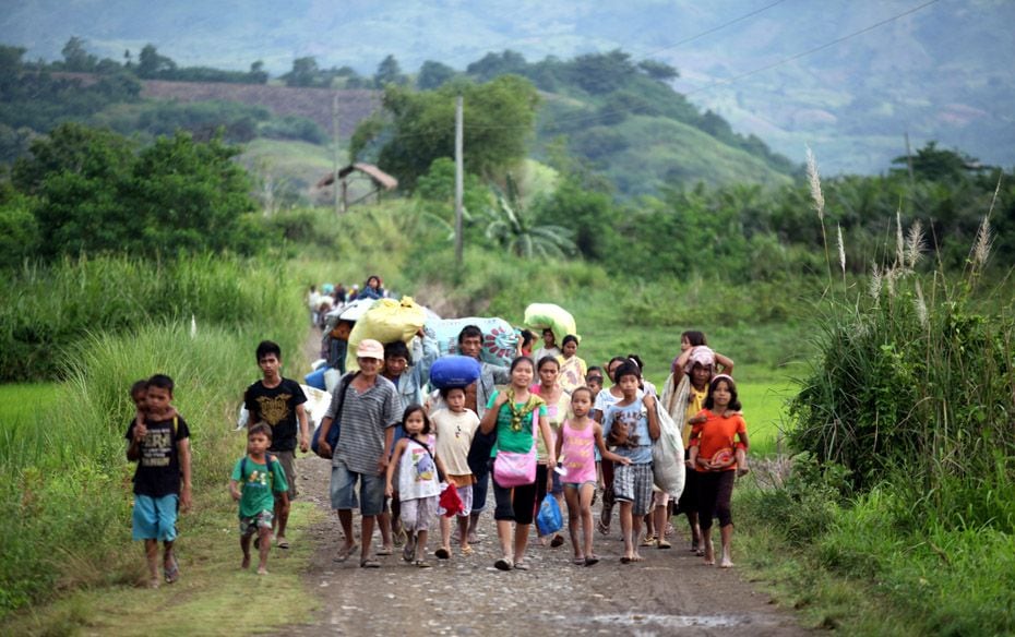 Residents of a remote village in the township of Ampatuan in the southern Philippines evacuate to sa