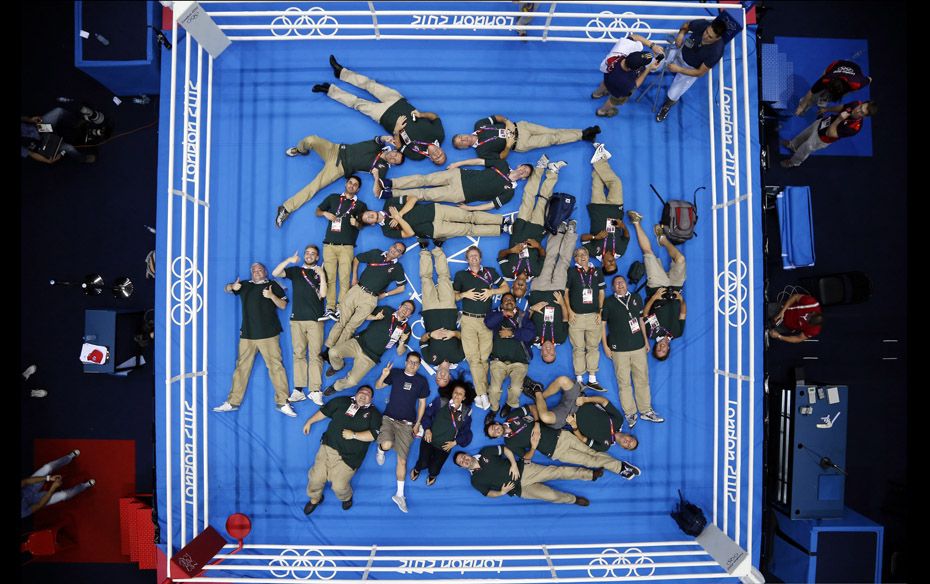 Technicians pose for a souvenir photo after the conclusion of the boxing event at the London Olympic