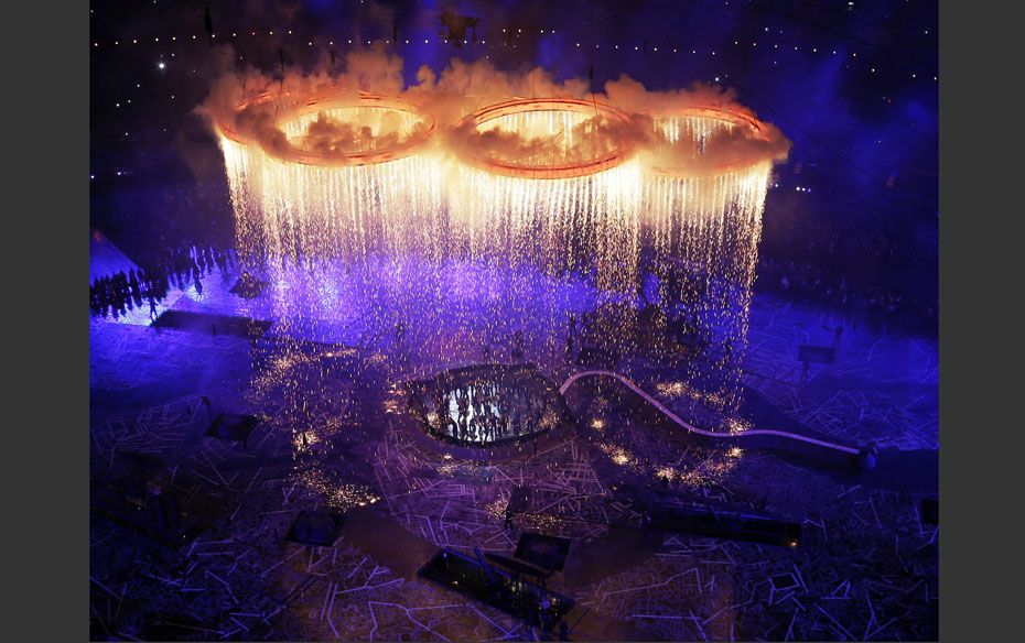 Rings representing both the Olympics and the Industrial Revolution are lit and lifted during the Ope