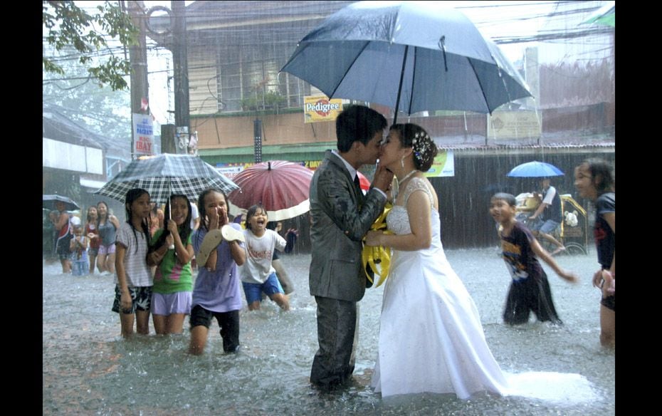 Ramoncito Campo kisses his wife Hernelie Ruazol Campo on a flooded street during a southwest monsoon