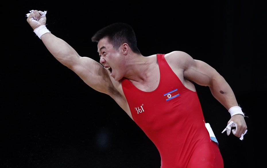 North Korea's Un Guk Kim reacts after a successful lift in the men's 62 kg Group A weightlif