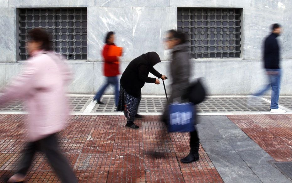 A woman begs as shoppers walk by in central Athens. Greeks resigned themselves to a 130-billion-euro