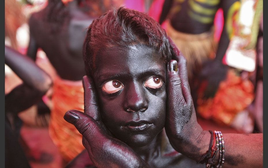 Nine-year-old Rahul gets his make-up done to look like a demon before the start of the procession ah