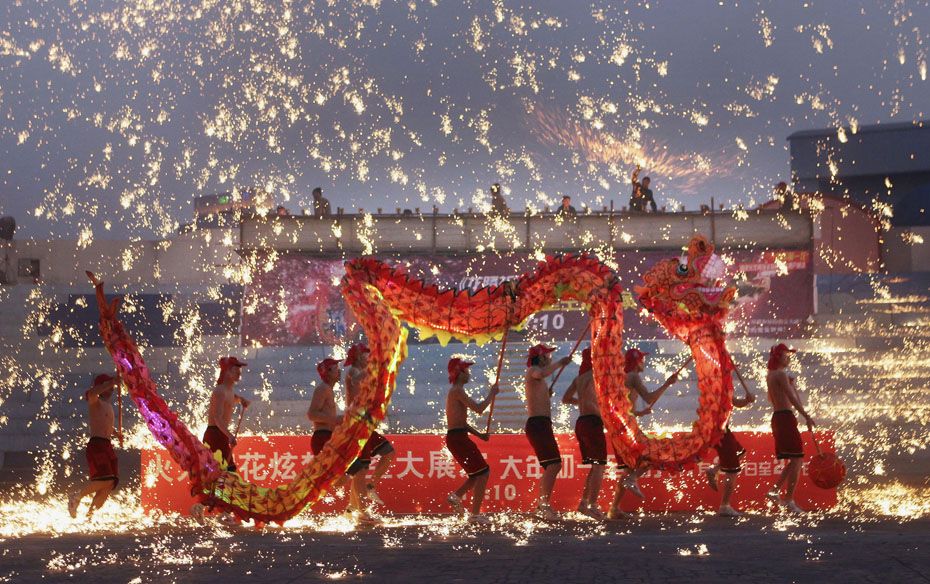 Folk artists perform a fire dragon dance amid molten iron at 1,300 degrees Celsius  during a Sp