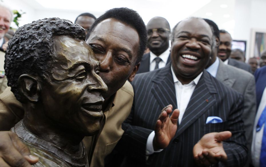 Gabon's President Ali Bongo Ondimba (Right) watches as Brazil's soccer legend Pele kisses hi