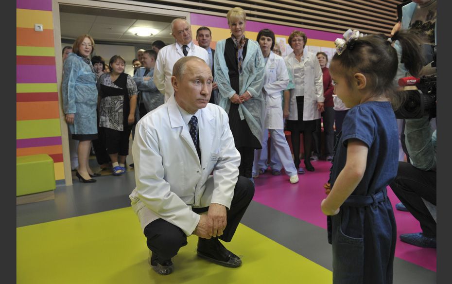 Russia's Prime Minister Vladimir Putin (Left) talks to a girl as he visits the Federal Scientifi