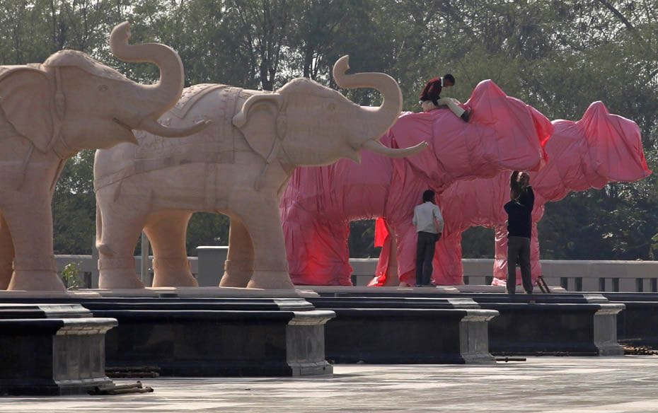 Workers cover elephant statues at a park in Noida. The Election Commission has ordered officials in 