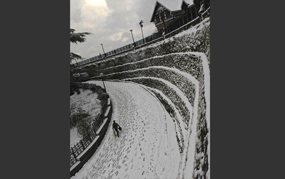 A man walks through a snow covered road after heavy snowfall in Shimla                         