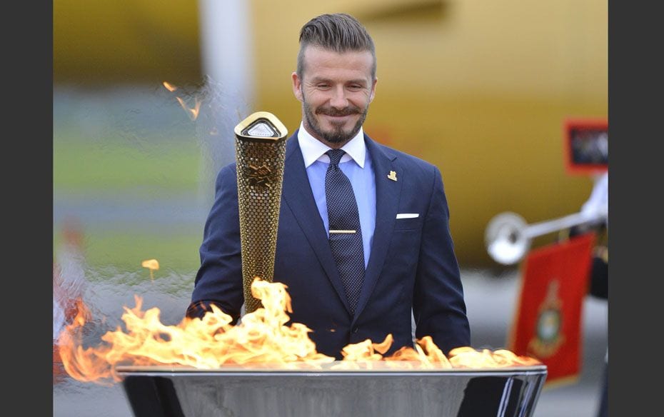 British soccer player and London 2012 Olympic Games ambassador David Beckham reacts after lighting t