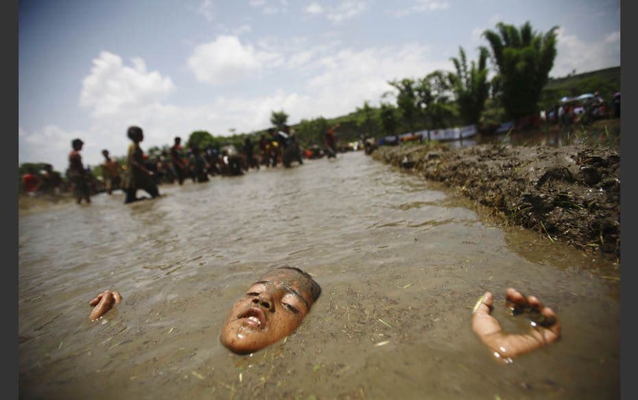 A boy enjoys lying down in mud while celebrating the Asar Pandhra festival in Pokhara valley, west o