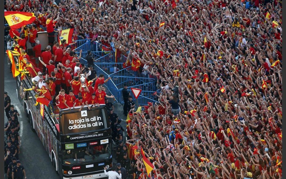 Spain’s national team soccer players celebrate on top of a bus with their supporters a day aft