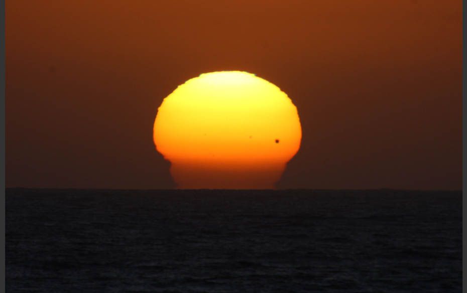 The planet Venus is seen as a black dot as it makes its transit across the sun over Tijuana, June 5,