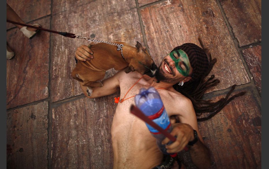 A student is licked by a dog as he lies on the floor at the end of a march at La Constitucion square