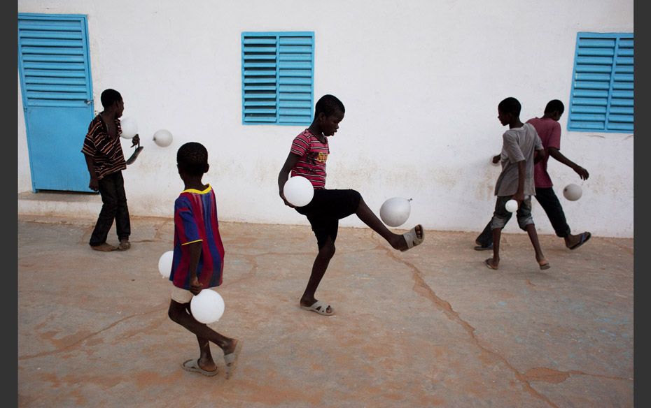 Boys play soccer with balloons after attending a dance recital in the town of Kaedi, Mauritania     