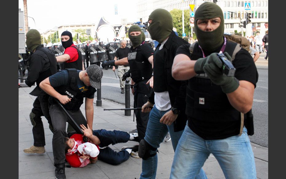 Plain clothes police officers arrest a soccer fan during clashes before the Group A Euro 2012 soccer