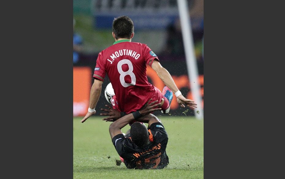 Portugal's Joao Moutinho falls over Netherlands' Jetro Willems during their Group B Euro 201