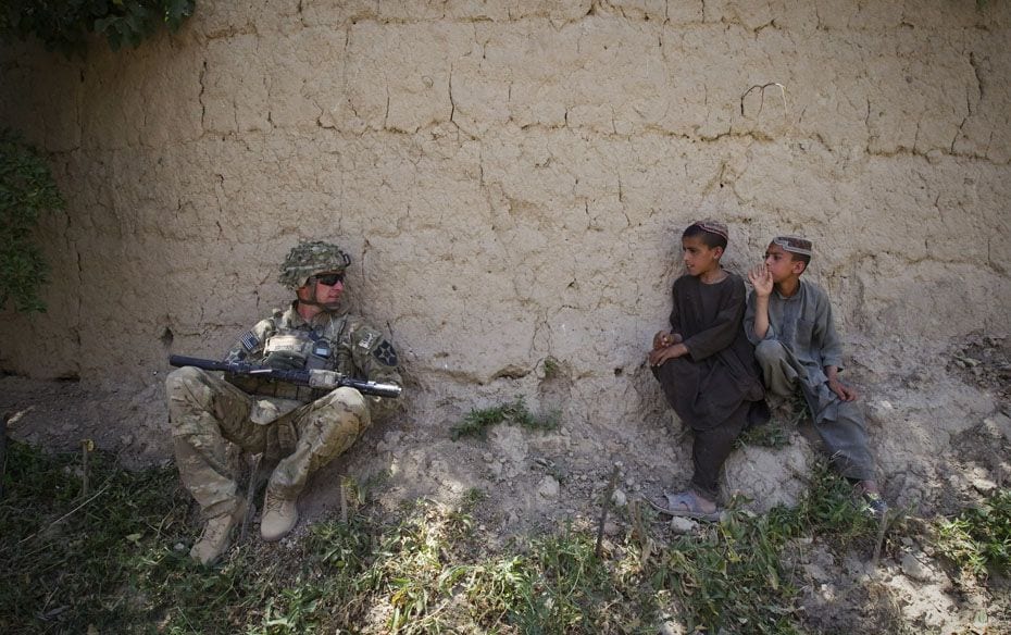 Afghan boys look at a US Army soldier of 5-20 Infantry Regiment attached to the 82nd Airborne Divisi