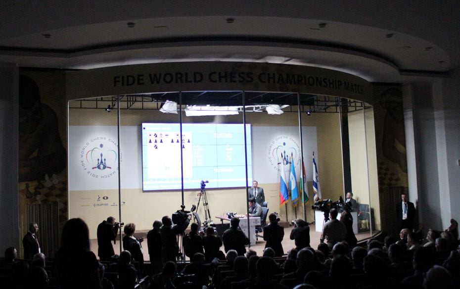 The players play inside a Glass Room, while spectators watch from outside