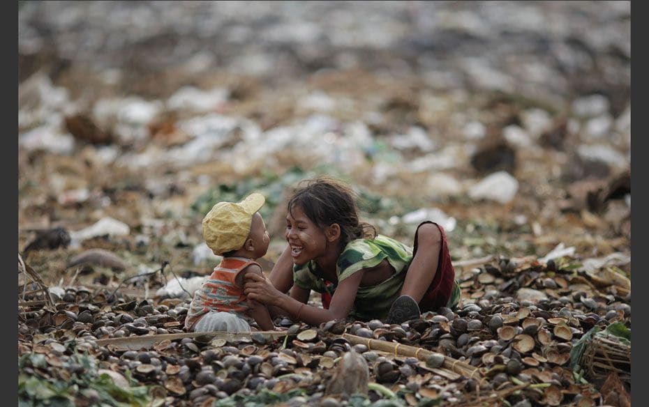 A girl plays with her brother as they search for usable items at junkyard near the Danyingone statio