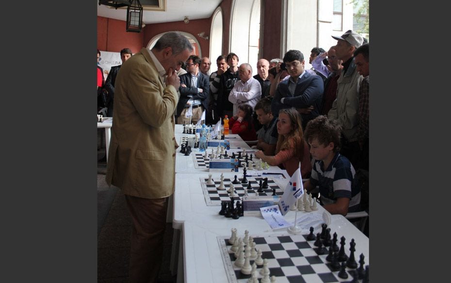 Former World Chess Champion Garry Kasparov in deep thought as he plays a simultaneous against young 