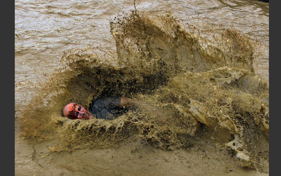 A zombie lands in a pool of water on the "Run for Your Lives" 5K obstacle course race in A