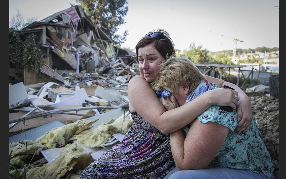 Tatyana Samokhval (L), daughter of local resident Sergei Khlystov, embraces her sobbing mother Valen