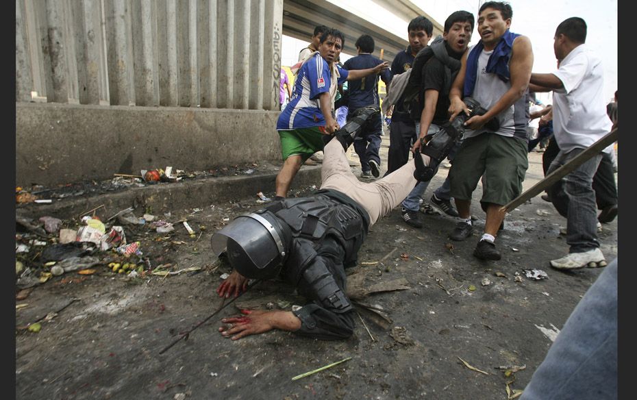 A riot police officer is dragged by protesters after being knocked down off his horse by workers of 