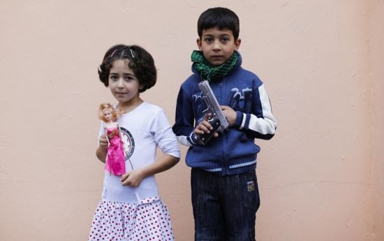 Mina, an eight-year-old Syrian refugee girl holding a baby doll, and Saad, an eight-year-old Syrian 