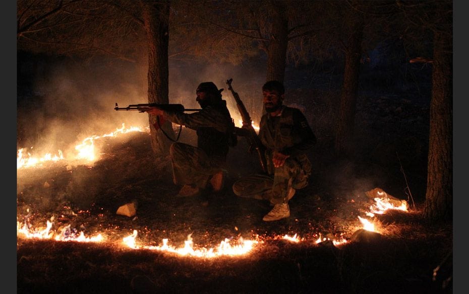 Members of the Free Syrian Army take up their positions during a truce atop a mountain in the Kurdis