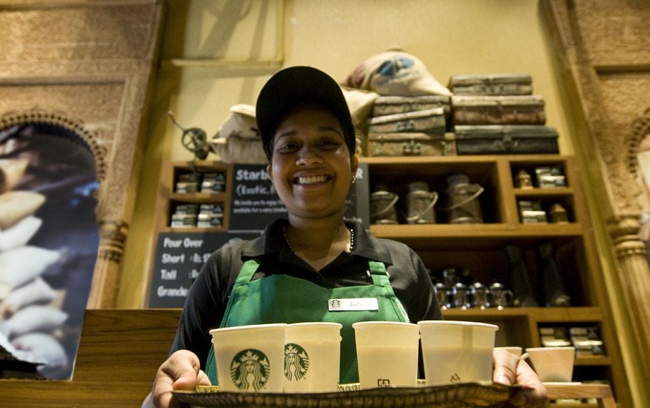 An employee hands out cups of vanilla latte to journalists                        