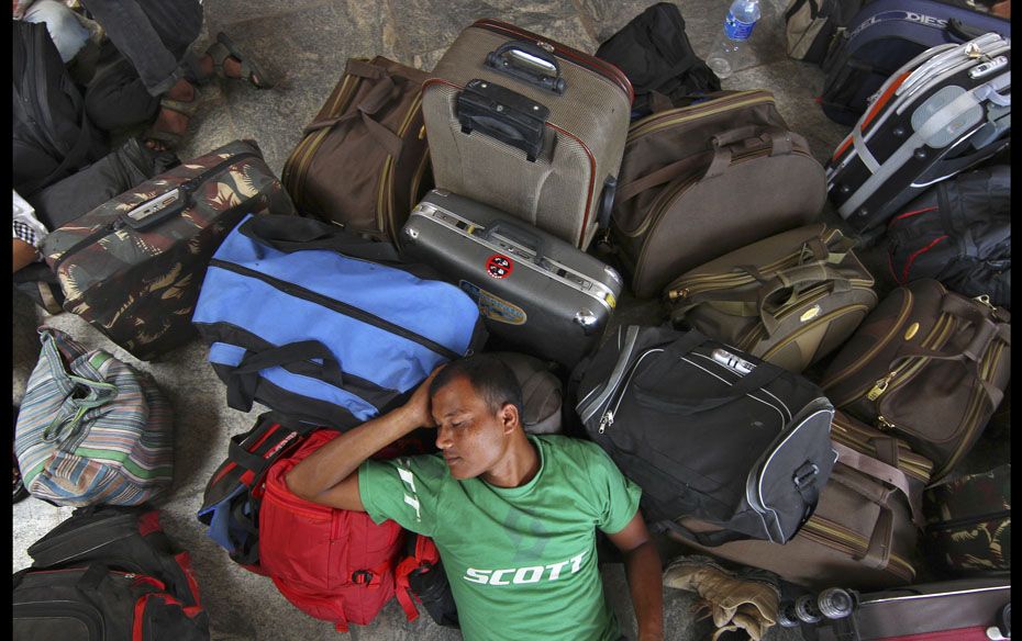 A man from India’s northeast takes a nap next to his luggage at a railway station in India&rsq