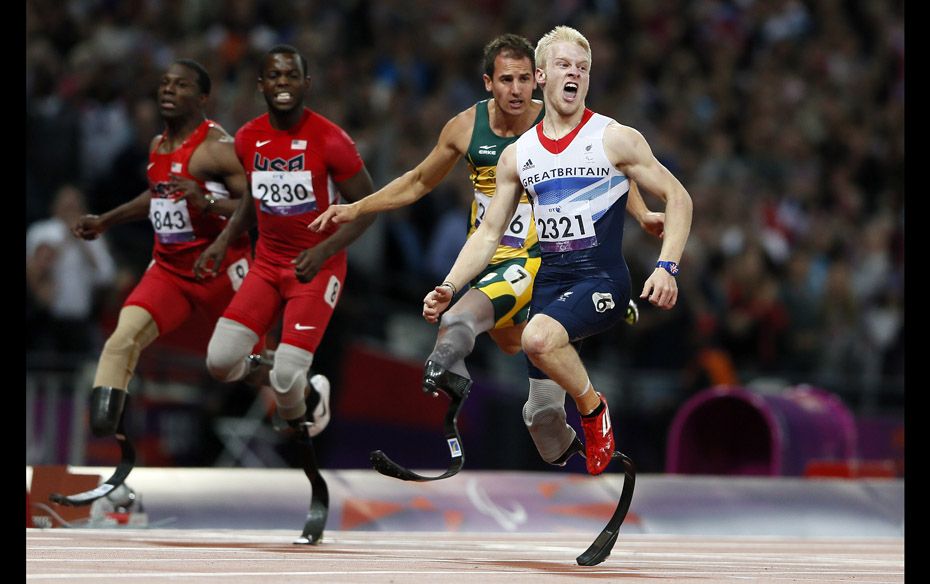 Britain's Jonnie Peacock (R) wins the Men's 100m T44 classification final at the Olympic Sta