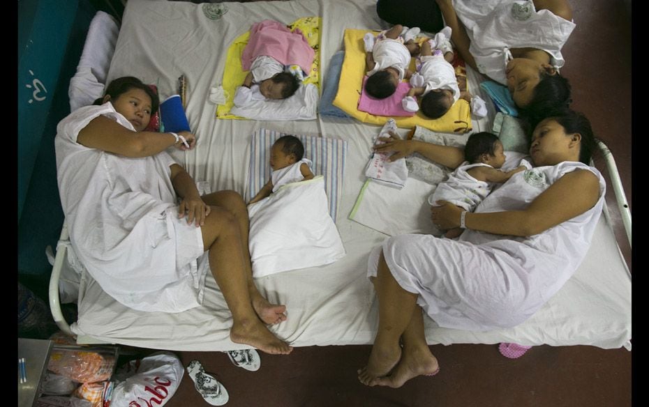 Mothers and their newborns share space on a bed in the maternity ward of the government-run Jose Fab