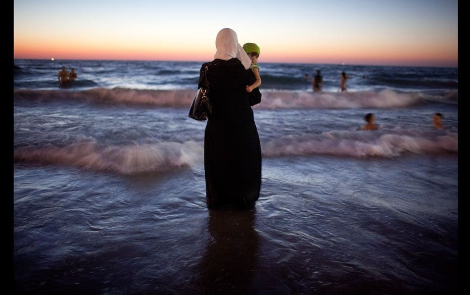 A woman holds her baby as Palestinians in Tel Aviv, Israel, enjoy a day at a beach during Eid al-Fit