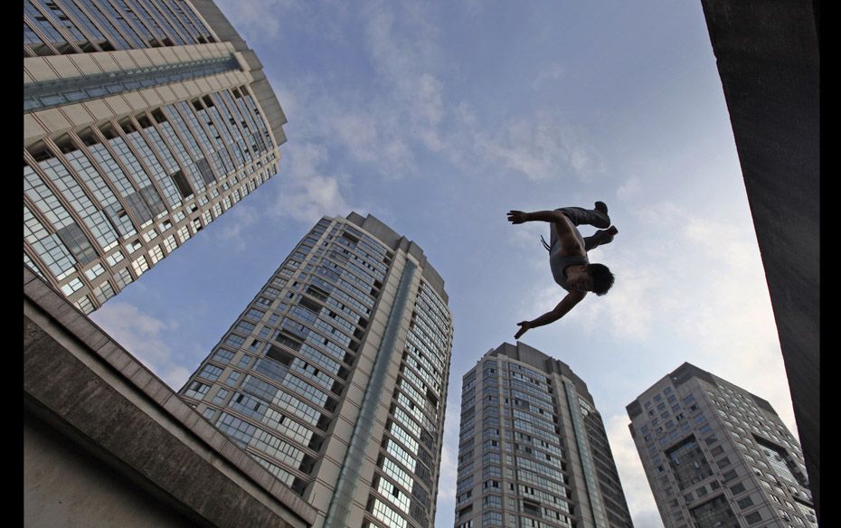 A youth jumps during a Parkour practice from the top of a seven-floor building in Taizhou, Zhejiang 