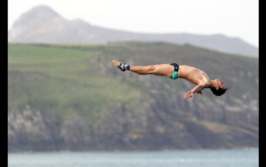 A diver takes part in the Red Bull Cliff Diving Competition at the Blue Lagoon at Abereiddy near St 