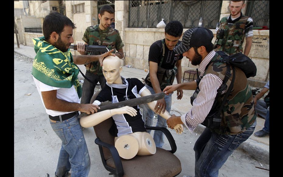 Free Syrian Army fighters dress a mannequin to look like a fighter during clashes in the Salaheddine