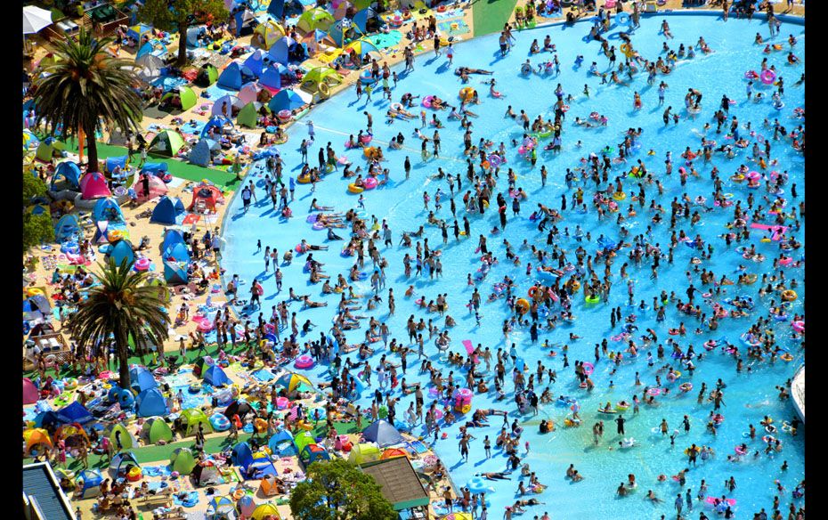 An aerial image of a swimming pool at the Toshimaen Amusement Park in Tokyo, Japan, filled with peop